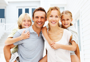 Happy family in front of house